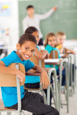 21290910 – smiling elementary school boy in classroom looking back