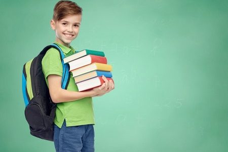 51808954 - childhood, school, education and people concept - happy smiling student boy with school bag and books over green school chalk board background